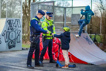 Twee politieambtenaren geven vuistje aan jongen in het skatepark