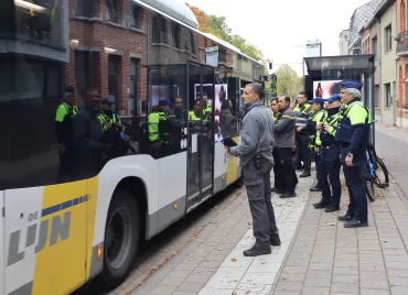 controleurs van De Lijn en inspecteurs van Politie Schoten wachten een bus op die stopt aan een halte
