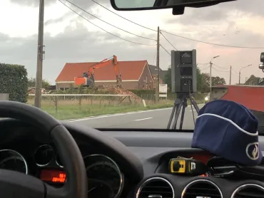 Dashboard flitsauto met politiebootje en zicht op flitstoestel
