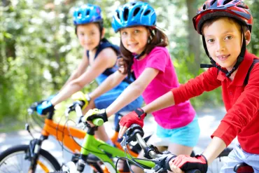 3 jonge kinderen met helm op de fiets