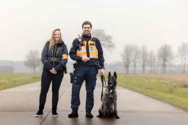 foto van 2 inspecteurs en 1 hond op de baan