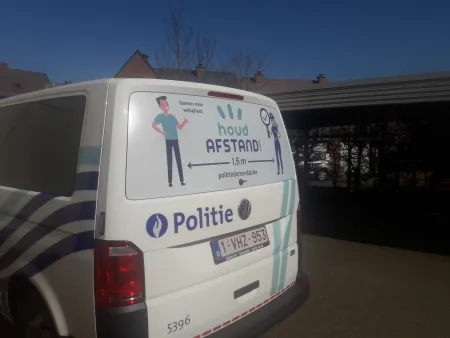 sticker op de politiecombi met als tekst houd afstand 