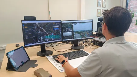 Dronepiloot die drone aanstuurt vanachter computer